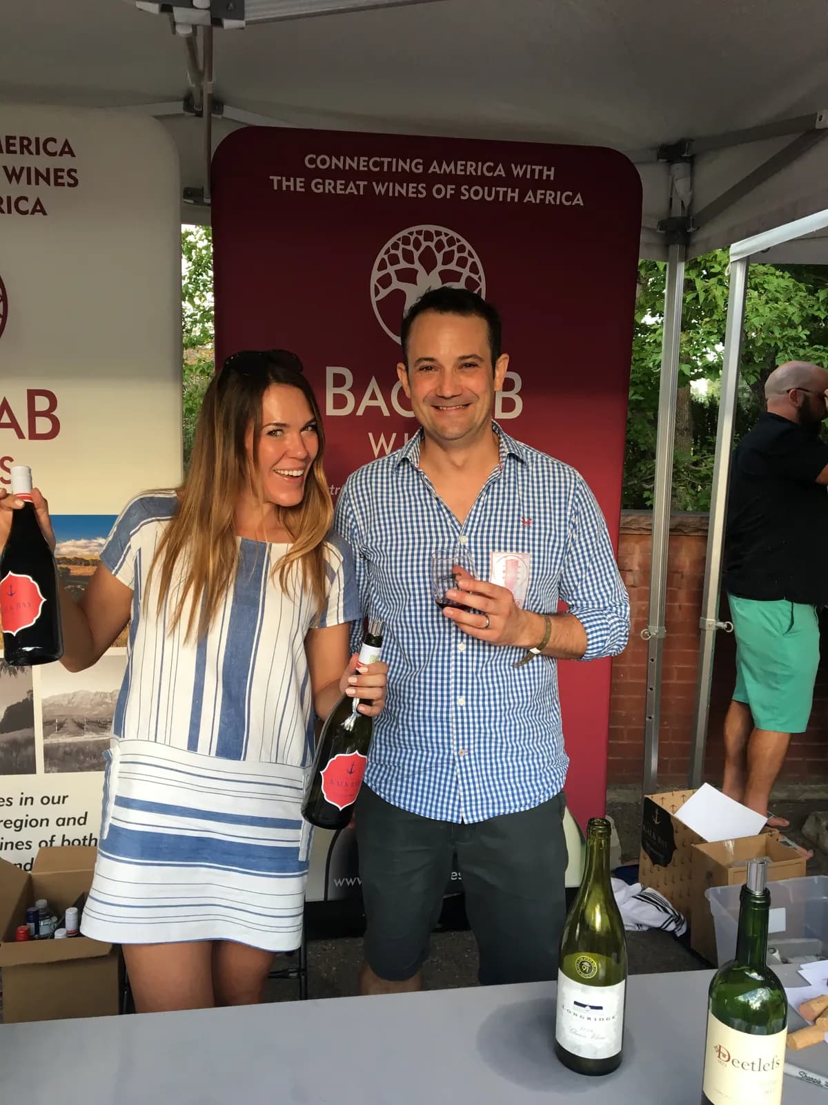 Pouring bottles at the Baobab Wines booth during a US trade show, branded backdrop behind