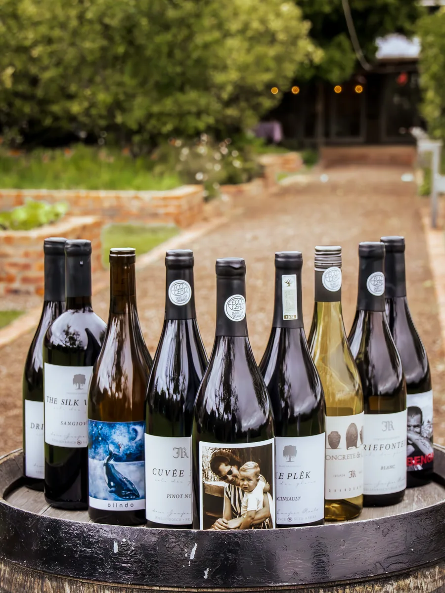 The Jasper Raats Single Vineyard Collection lined up on a wine barrel