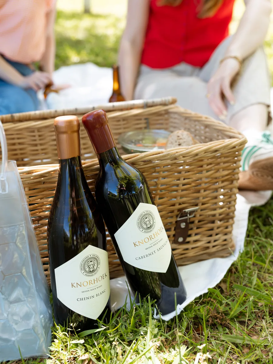 Knorhoek Chenin Blanc and Cabernet Sauvignon bottles at a picnic on the estate