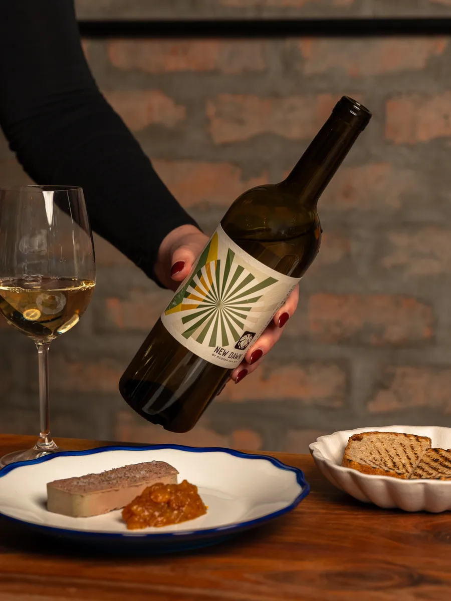 A New Dawn bottle and glass served with a meal